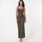 A sleeveless maxi tank dress featuring bold vertical stripes in black and warm beige. The dress is shown in a textured ribbed knit with a modern scoop neck and a subtle side slit, emphasizing a sleek, elongated silhouette for summer.
