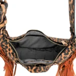 Top-down view into the open, zippered compartment of the leopard print handbag, showing a black and white chevron patterned lining