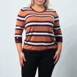 Plus size woman wearing a rust and brown striped knit sweater with decorative gold buttons on the shoulder.