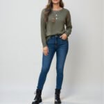 Model wearing a vibrant green long-sleeve sweater featuring a cozy ribbed knit texture, a classic crew neckline, and a flattering body-skimming fit for a fresh spring look.